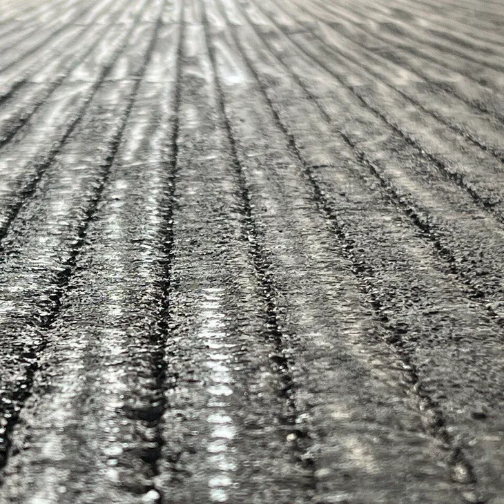 Close-up of a MECWEAR chromium carbide overlay wear plate showing the characteristic ridged weld-bead surface